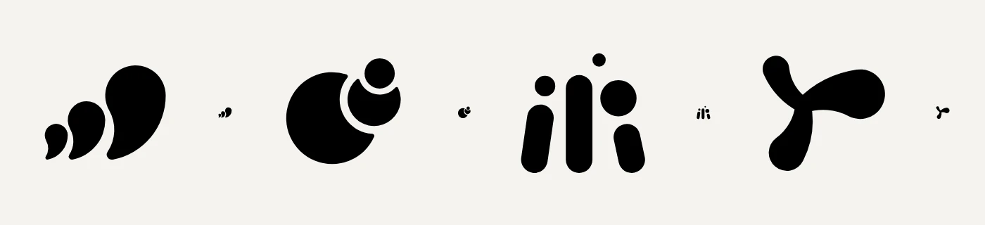 Four black marks, each beside a tiny copy of itself: three comma shapes growing in size, a large circle with a small one nested at its edge, three upright bars with dots above them, and a three armed shape like a turning figure.