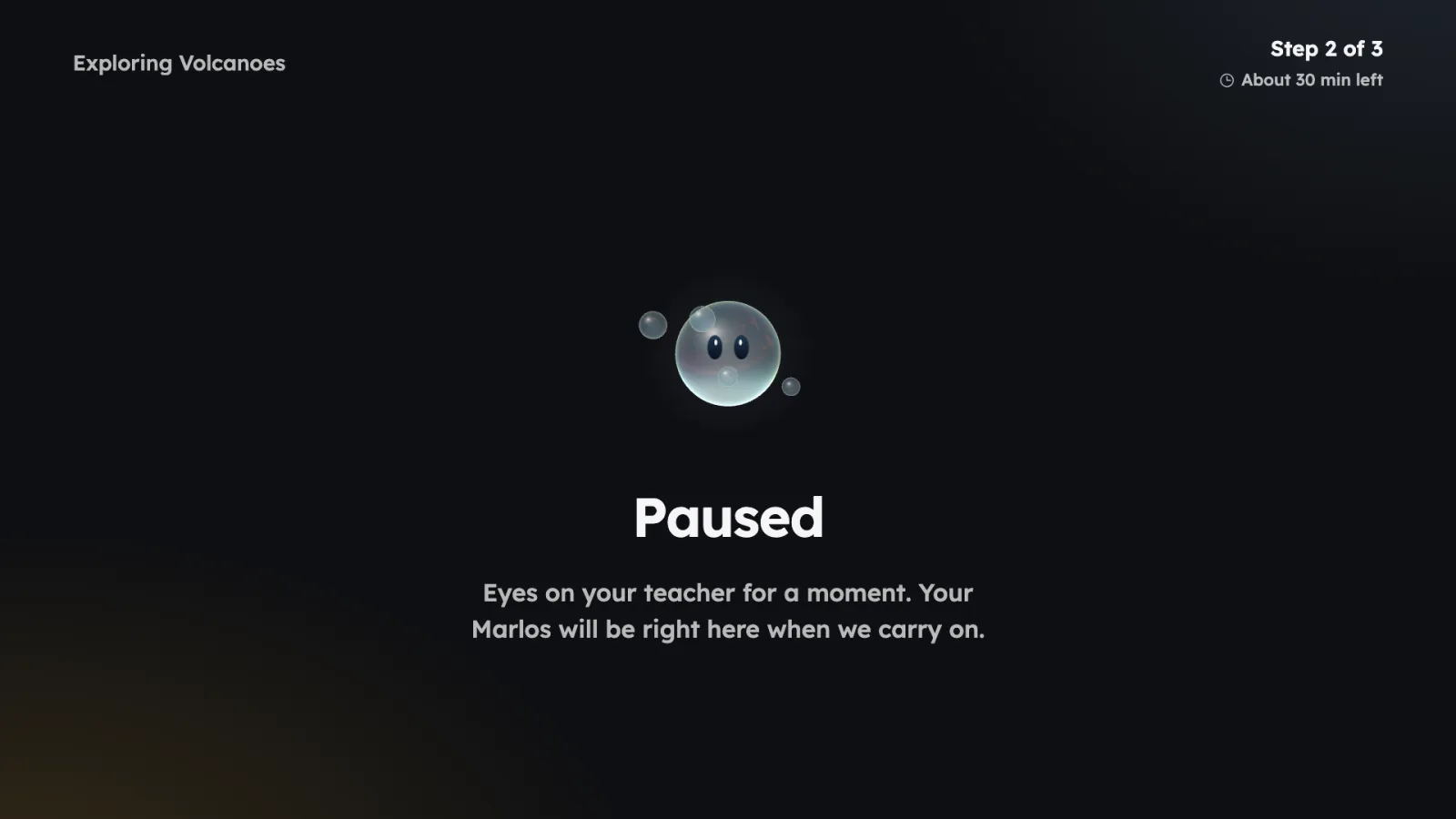 Projector view while the class is paused: Marlos above the word Paused and the line Eyes on your teacher for a moment. Your Marlos will be right here when we carry on.