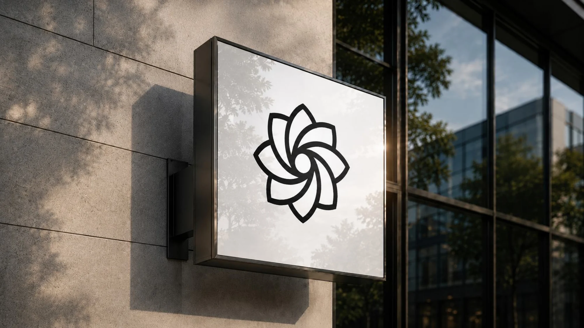A square sign fixed to a concrete wall beside a glass front: on its white face the Sovara Labs logo icon in black, a pinwheel of eight curved petals.
