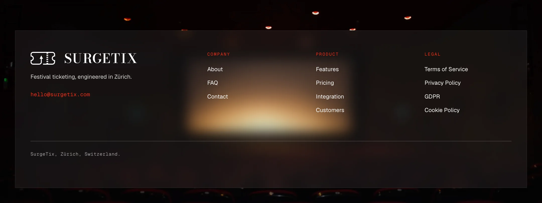 The foot of the site: a dark translucent panel over a dim cinema hall with a warm glow, the logo with the line Festival ticketing, engineered in Zürich and an email address in red, and three columns of links under the red headings Company, Product and Legal.