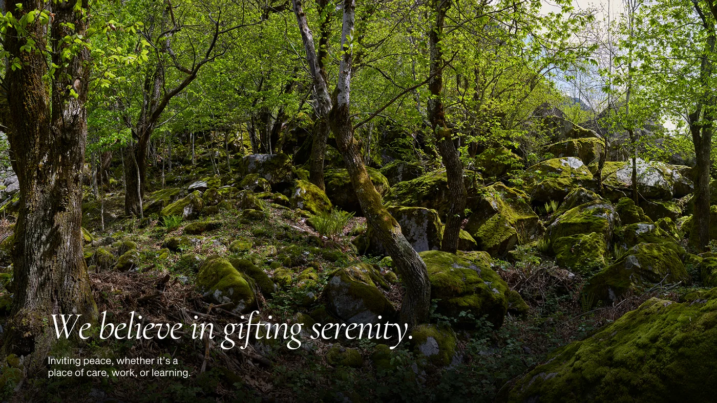 The same page in the file named 1V: the forest photograph fills the page and the line We believe in gifting serenity stands at the bottom left in serif italics.