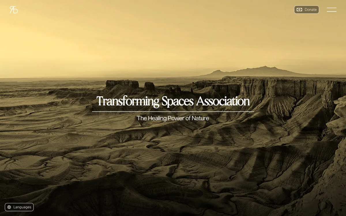 The top of the home page: a sand coloured panorama of a canyon landscape fills the screen. In the middle the name Transforming Spaces Association stands on a thin white rule above the line The Healing Power of Nature. The logo is at the top left, a Donate button and a menu at the top right, a Languages button at the bottom left.