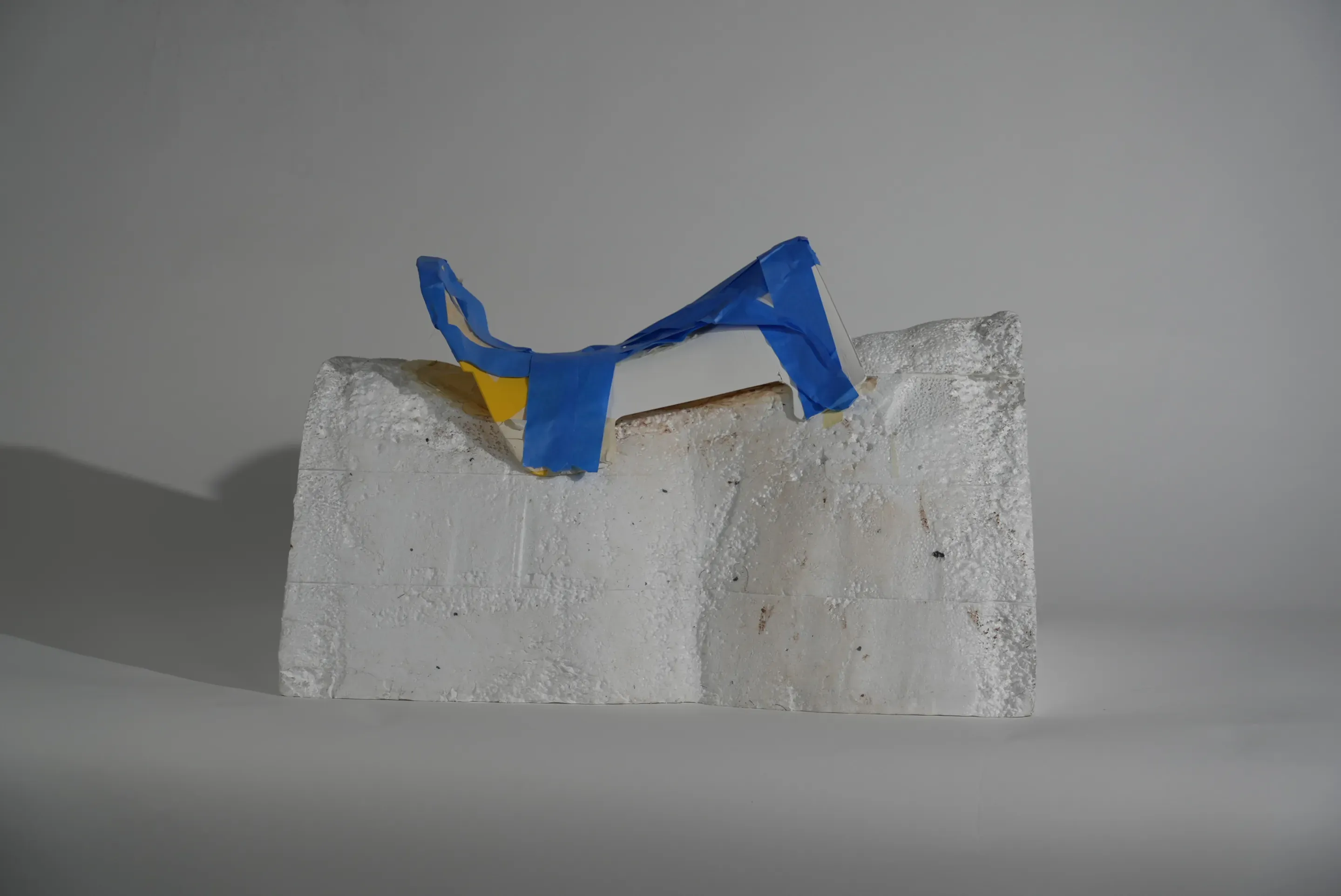 Prototype step: a tree frame wrapped in blue tape with yellow parts on the foam block.