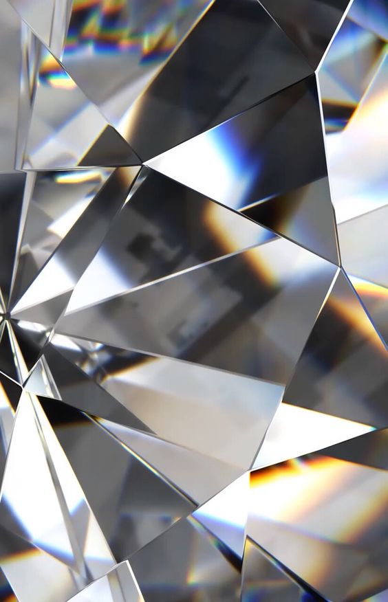 Moodboard picture: close view of clear crystal facets with sharp edges and small rainbow reflections.