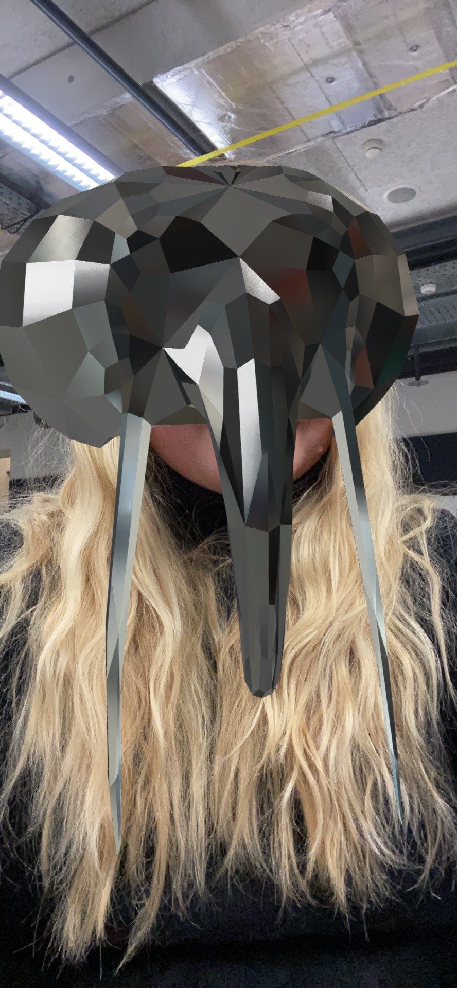 Selfie from the Spark AR prototype: the grey elephant mask with long tusks covers the face of the woman with long blonde hair.