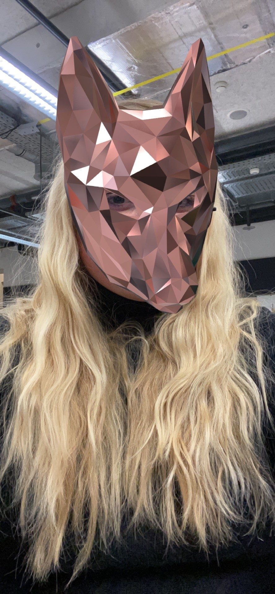 Selfie from the Spark AR prototype: a copper coloured low poly fox mask covers the face of the woman with long blonde hair.