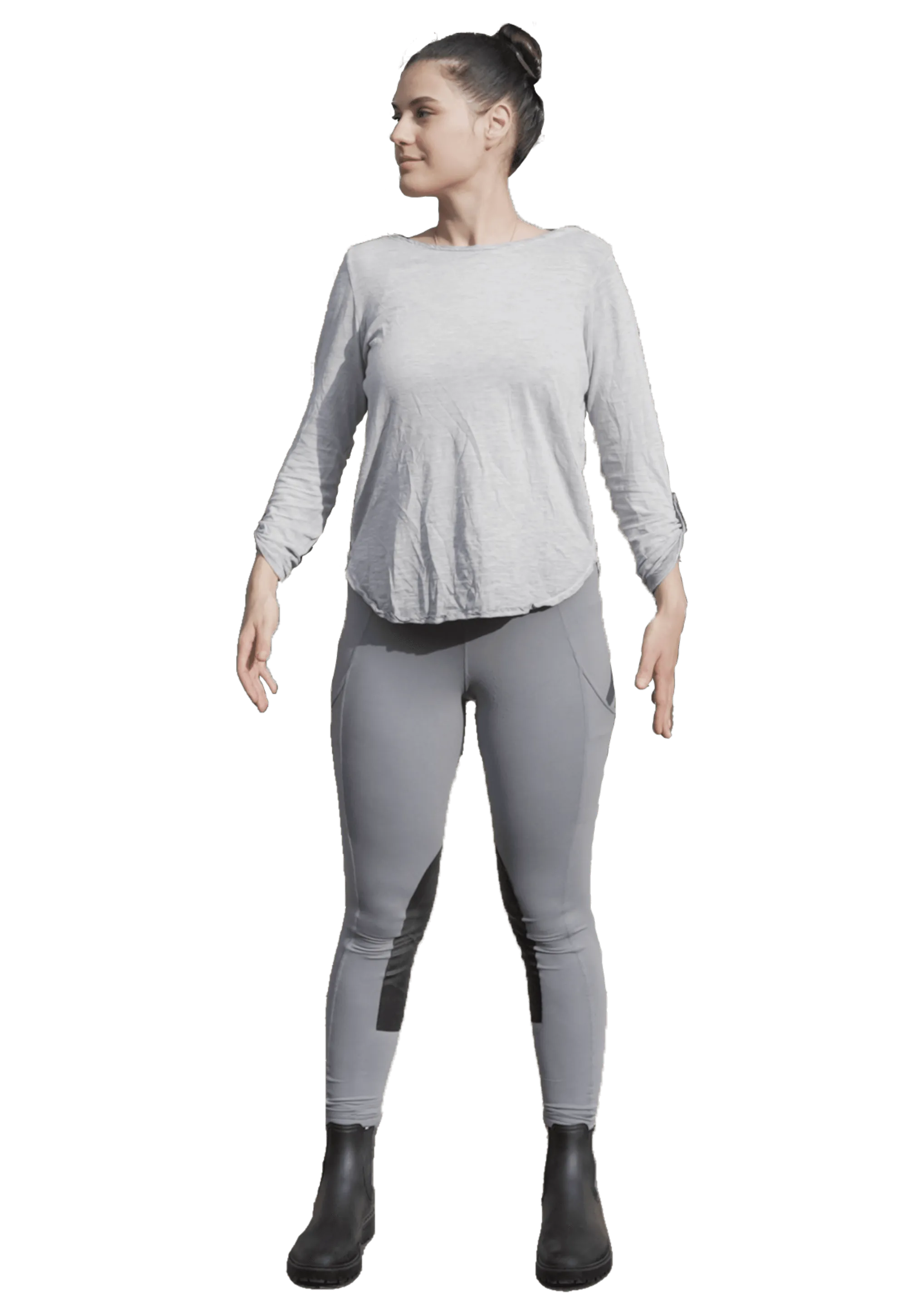 3D model of a woman standing with her arms slightly away from the body, in a grey top, grey riding leggings and black boots.
