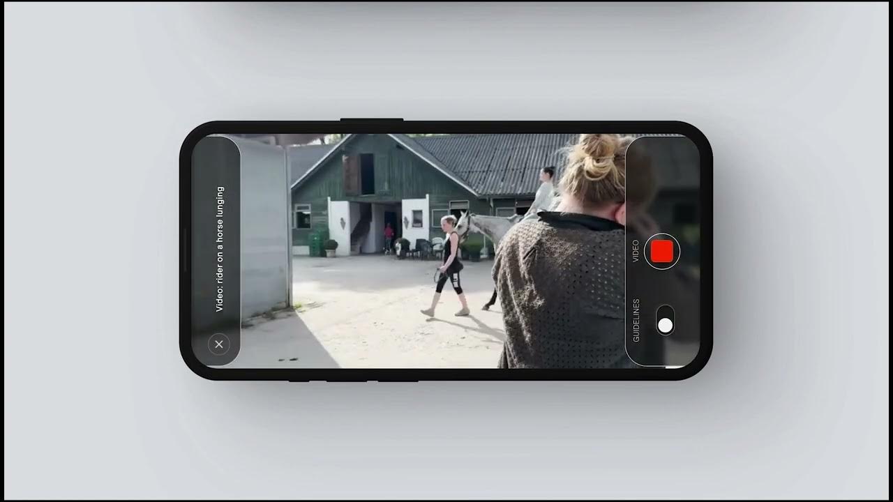 Film still: a phone held sideways records a rider and a horse in a yard, over the shoulder of a person in the foreground.
